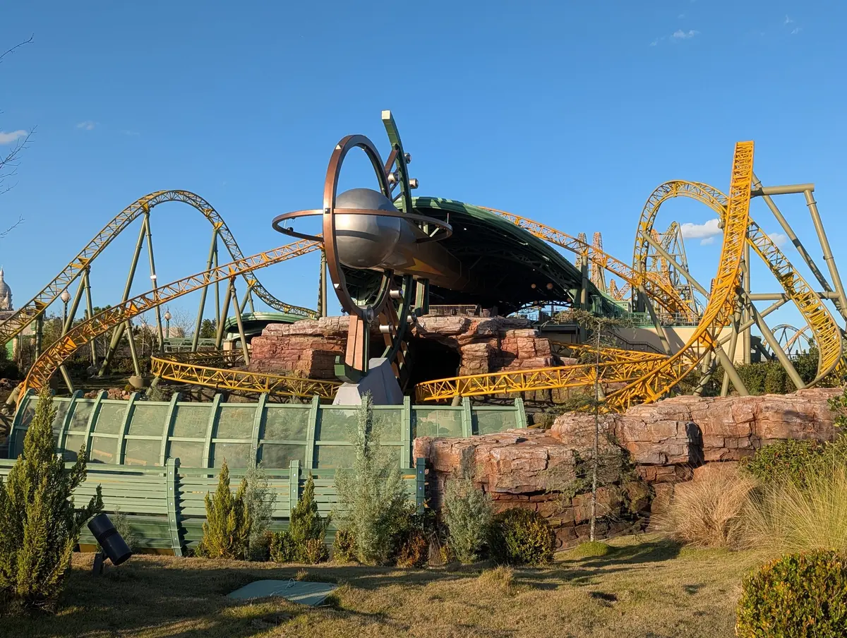 Stardust Racers' yellow coaster tracks looping around a planet sculpture in Celestial Park, Epic Universe