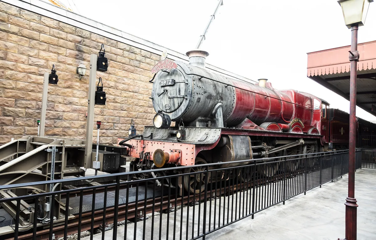 The red Hogwarts Express locomotive beside the stone walls of Hogsmeade Station, Islands of Adventure