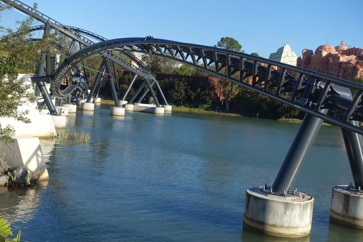 Jurassic World VelociCoaster's dark steel track curving over the lagoon at Islands of Adventure