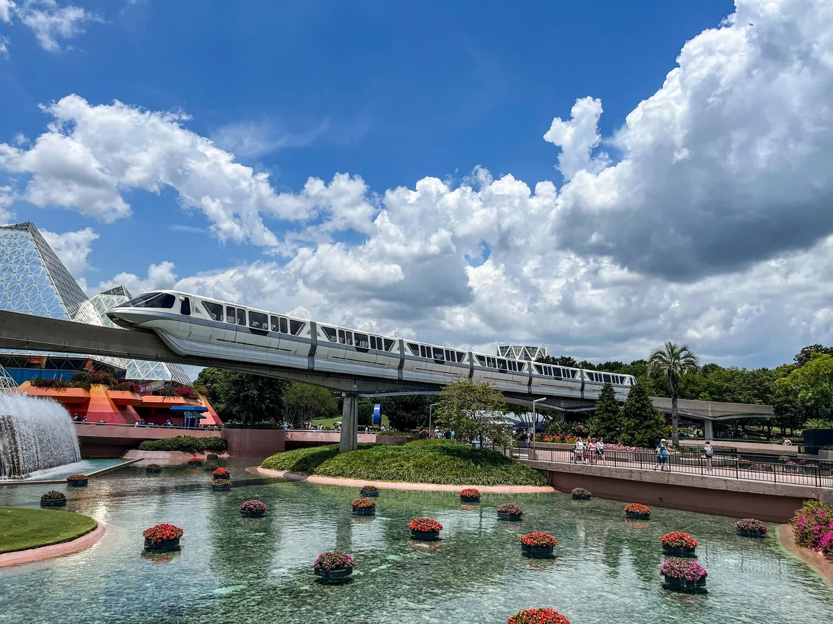 Walt Disney World monorail train on its beamway above the flower-filled fountain pools at EPCOT