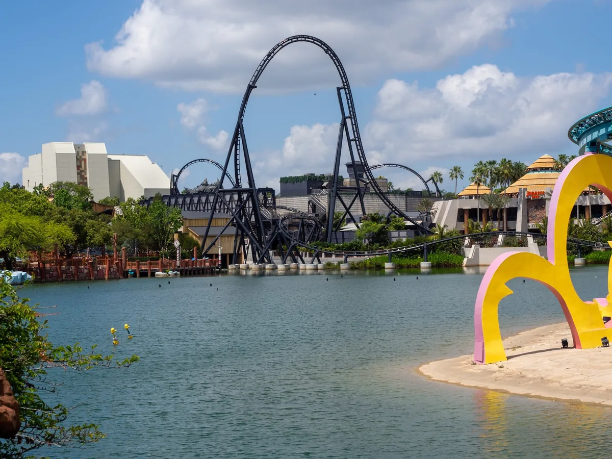VelociCoaster loops rising over the lagoon at Universal Islands of Adventure on a sunny day