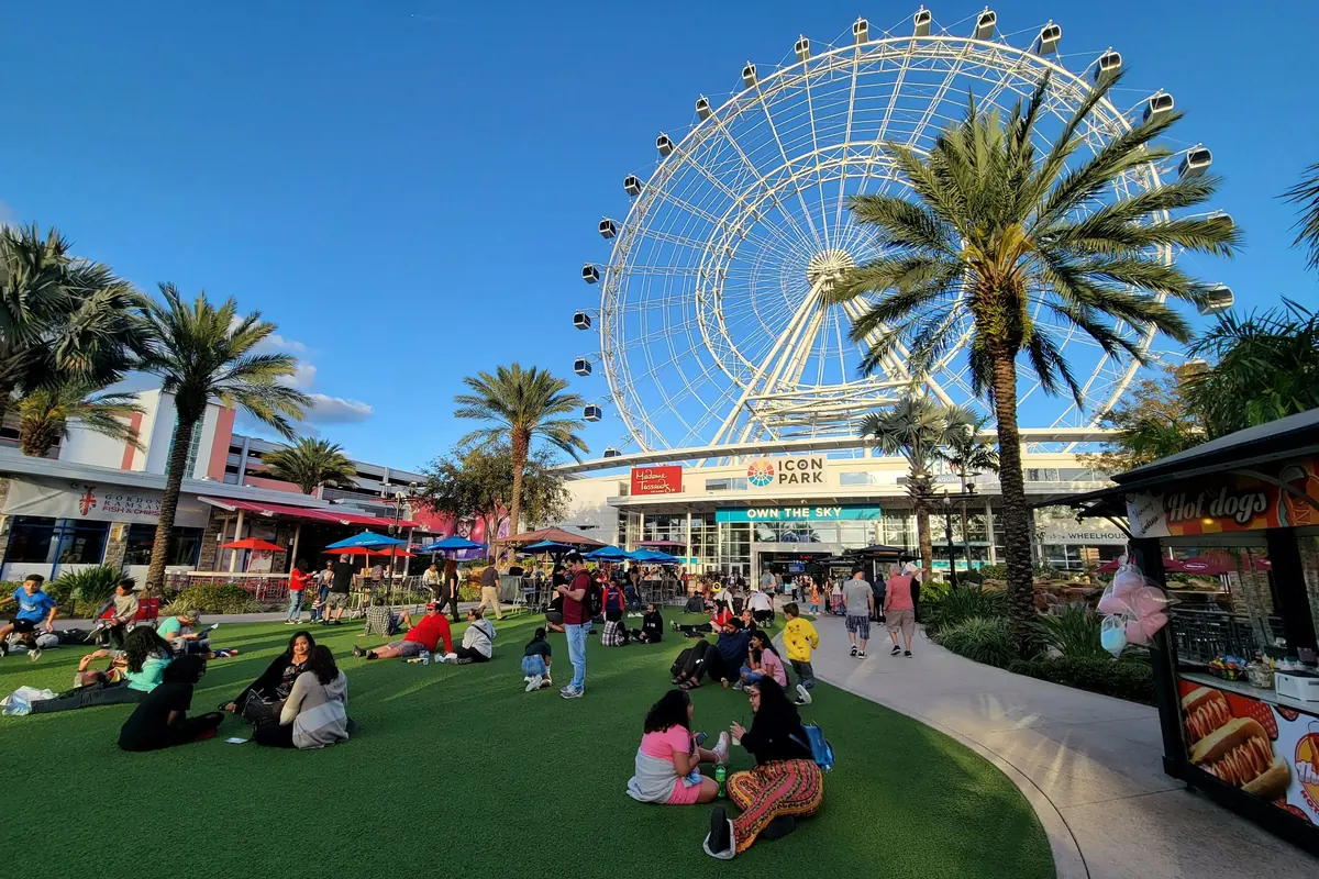 The Orlando Eye wheel above palm trees and shops at ICON Park on International Drive
