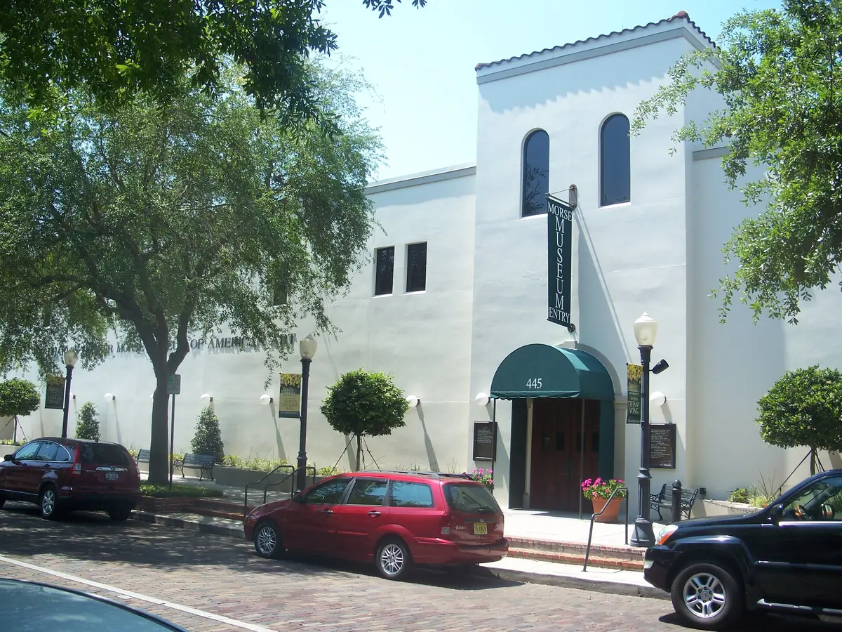 White facade and green-awninged entrance of the Morse Museum on Park Avenue in Winter Park