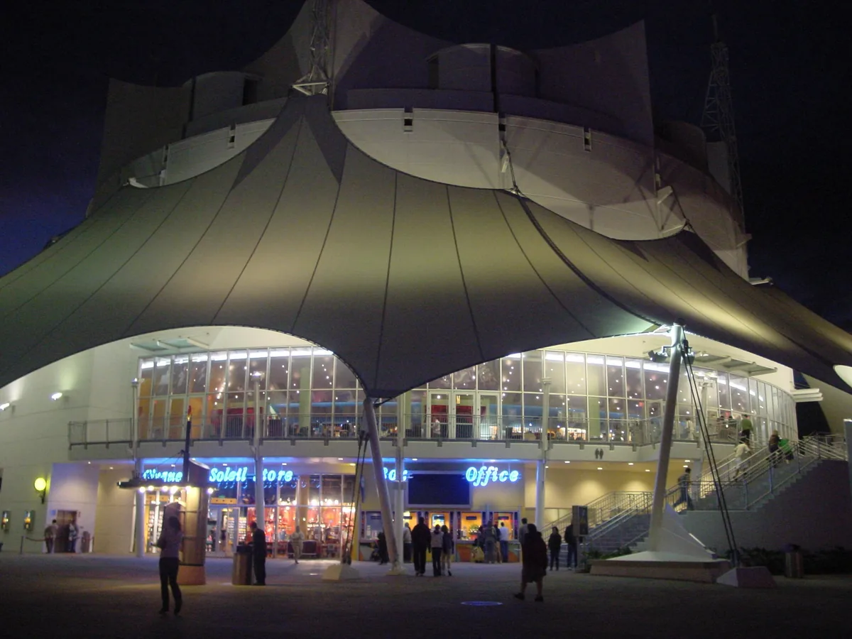 The Cirque du Soleil theater at Disney Springs lit up at night beneath its white tent-like canopy