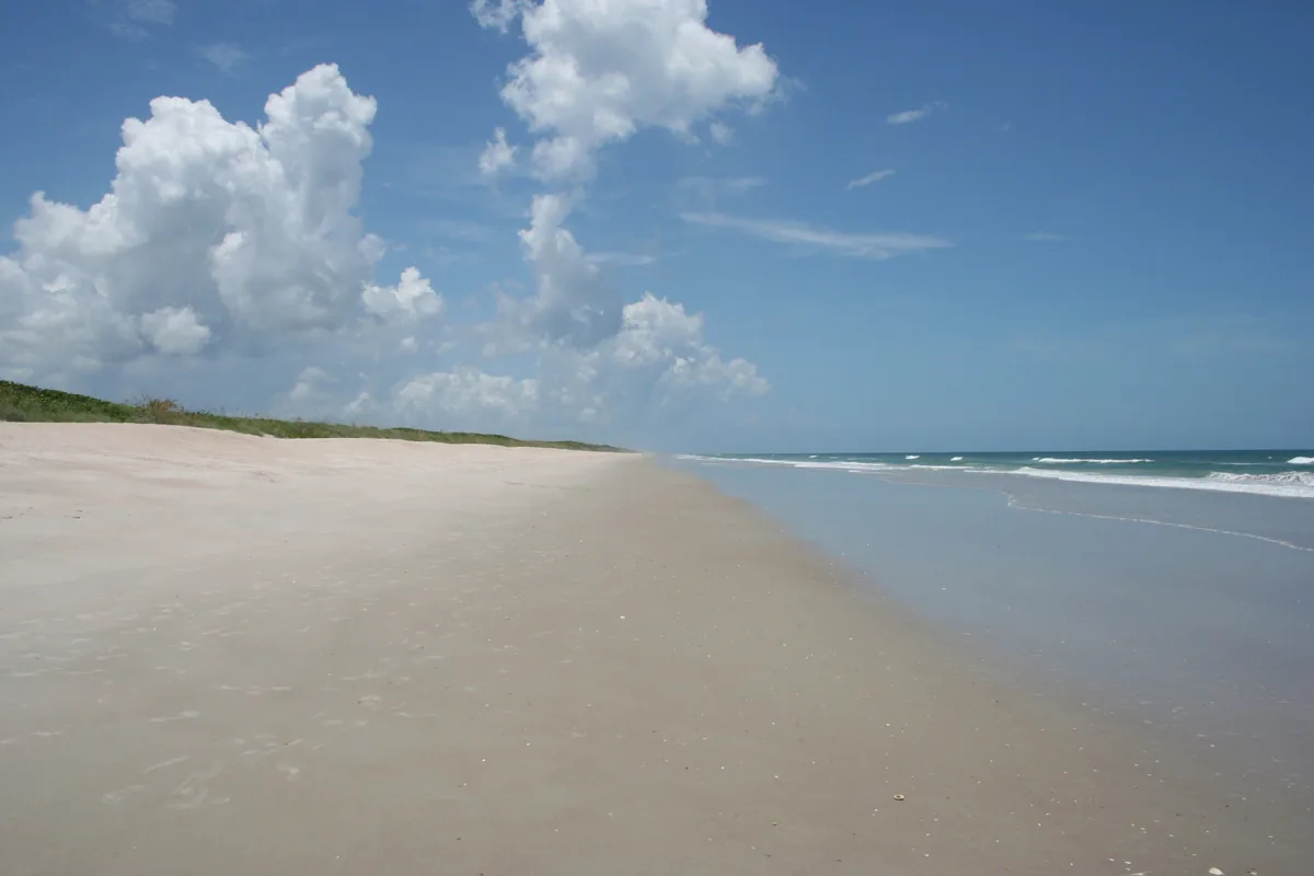 The wide, empty sand and low dunes of Playalinda Beach in Canaveral National Seashore
