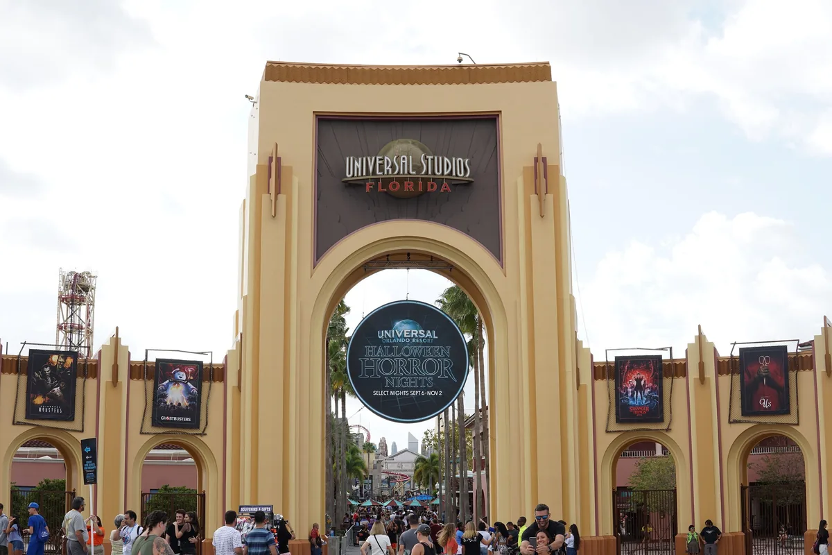 Universal Studios Florida entrance arch with a Halloween Horror Nights sign and horror banners