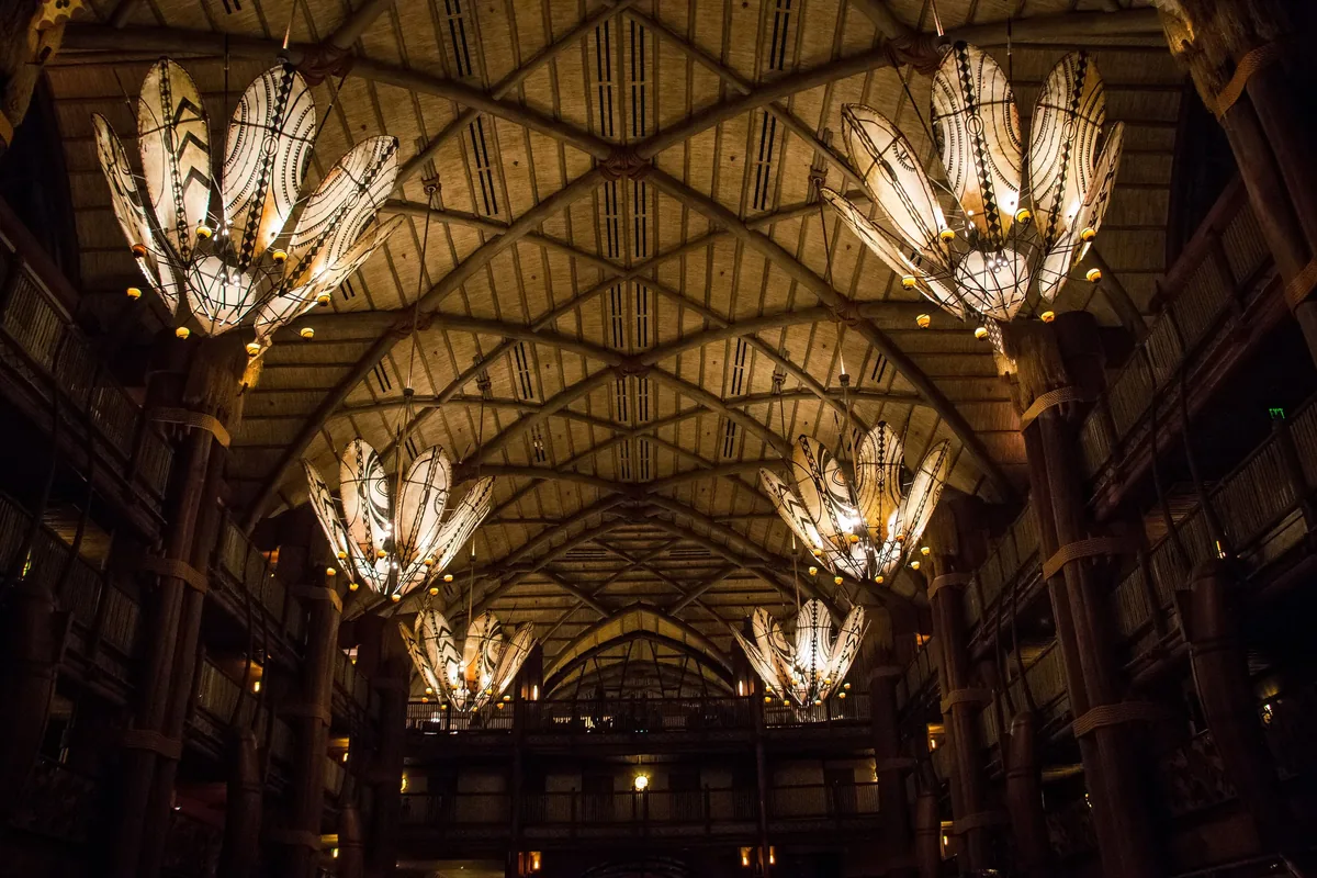 Timber-beamed lobby of Disney's Animal Kingdom Lodge with large African-style chandeliers
