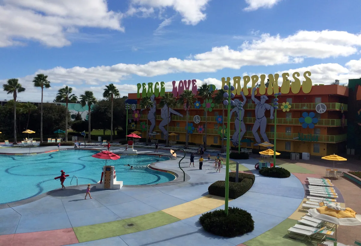 Hippy Dippy Pool at Disney's Pop Century Resort with 1960s-themed buildings and giant decorations