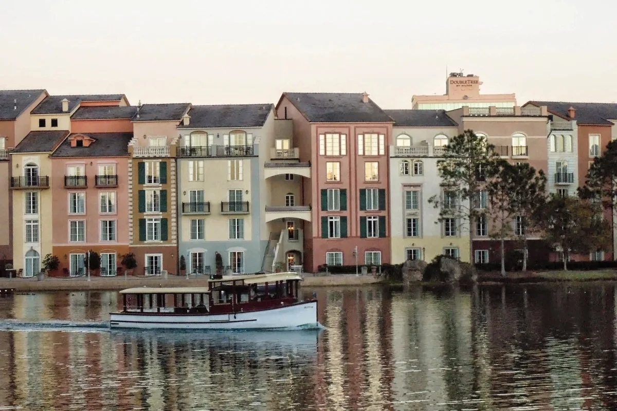 Pastel harborfront facades of Loews Portofino Bay Hotel with a water taxi on the bay