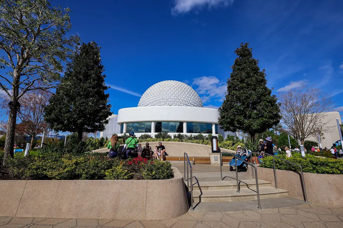 Spaceship Earth's geodesic sphere behind the gardens of Dreamers Point at EPCOT on a sunny day